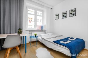 a bedroom with a bed and a desk and a chair at Prime Home CENTRUM in Gdynia