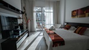 a bedroom with a large bed and a television at Sea Point By D&G in Carilo +36 photos