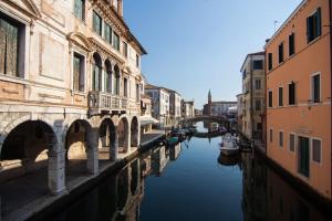 un canal dans une ville avec des bâtiments et un pont dans l'établissement ANGOLO DI LUCE, à Chioggia