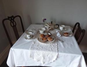 a white table with cupcakes and teapots on it at Carriglea in Listowel
