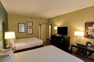 a hotel room with two beds and a flat screen tv at La Cuesta Inn in San Luis Obispo