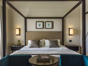 1 dormitorio con 1 cama y 2 sillas azules en DOGANA RESORT, en Molfetta