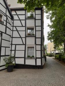 a black and white building with windows and potted plants at Historisch übernachten Brinkerplatz 3 in Essen