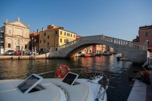 a boat in the water with a bridge in the background at A 3 PASSI DAL MARE in Chioggia