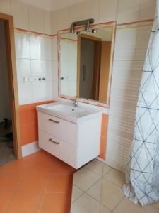 La salle de bains est pourvue d'un lavabo blanc et d'un miroir. dans l'établissement Apartmány pod Divadlem, à Znojmo