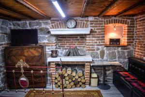 a room with a stone wall with a stove and a clock at Guest House Antika in Prilep