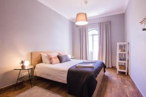 a bedroom with a bed and a table in it at Faro Central - Holiday Apartments in Faro