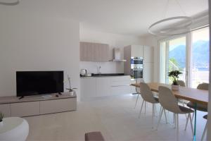 uma cozinha e sala de jantar com uma mesa e uma televisão em Appartamento Fiordaliso Bellagio Wild Flowers - HOT TUB em Onno