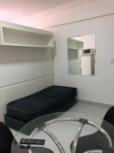a small room with a bed and a glass table at Apartamento pertinho da UEM/Novo Centro in Maringá
