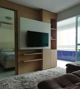 uma sala de estar com uma televisão de ecrã plano na parede em Beach Class Rosalux 707 em Fortaleza