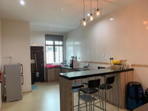 a kitchen with a bar with stools and a refrigerator at Jonker 88 Homestay Melaka in Malacca