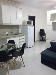 a kitchen with a table and chairs and a refrigerator at Apartamento pertinho da UEM/Novo Centro in Maringá