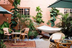 een hangmat op een patio met stoelen en een tafel bij Life House, Little Havana in Miami