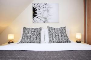 1 dormitorio con 1 cama blanca y 2 almohadas en Apartmán U Sikorek en Říčky