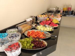 a buffet with plates of fruit and vegetables on a counter at Hotel Brio in Salinópolis