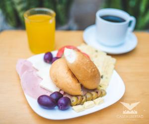 un plato de comida con un sándwich y frijoles y una taza de café en Casita Libertad Barranco en Lima