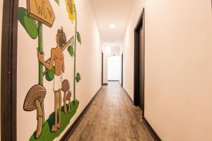 a hallway with a mural of mushrooms on the wall at Hostellicious in Faro