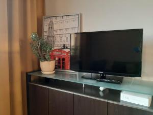 a flat screen tv sitting on top of a cabinet at Airport Residence Amber in Warsaw