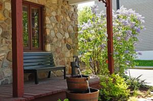 un banc sur une terrasse couverte à côté d'un bâtiment fleuri dans l'établissement Refuge du Poète, à Longueuil