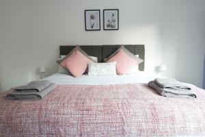 een slaapkamer met een groot bed met roze kussens bij Canal House in Chester