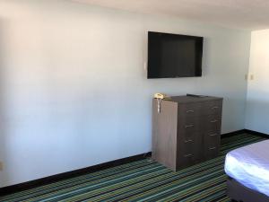 a room with a tv and a dresser and a bedroom at Brookings Inn Resort in Brookings