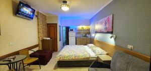 Habitación de hotel con cama y sala de estar. en Aloni - Guest house Dead Sea en Neve Zohar