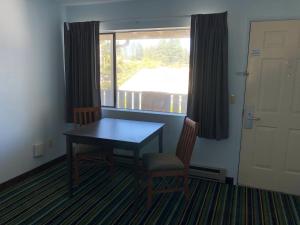 Habitación con mesa, 2 sillas y ventana en Brookings Inn Resort, en Brookings