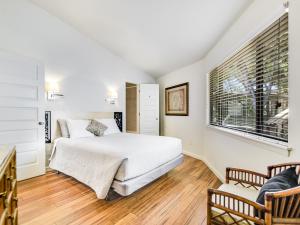 a white bedroom with a bed and a window at Lakefront Treehouse on Lake Travis Pool & Hot Tub in Lakeway +36 photos