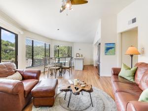 a living room with a couch and a table at Lakefront Treehouse on Lake Travis Pool & Hot Tub in Lakeway