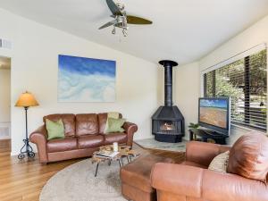 sala de estar con muebles de cuero y chimenea en The Treehouse On Lake Travis en Lakeway