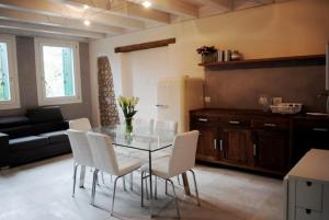 a dining room with a glass table and white chairs at Bed And Breakfast Castello in Villafranca di Verona