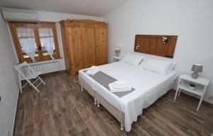 a bedroom with a white bed and a wooden floor at BLUE HOUSE by PerryHolidays-Reservations in Gioiosa Marea