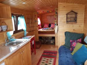 a kitchen with a sink and a room with a bed at La Roulotte du Haut Pinleu in Pernes-lès-Boulogne