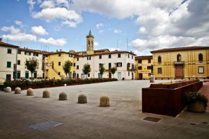 eine Gruppe von Gebäuden in einem Innenhof mit einem Uhrturm in der Unterkunft Alla Porta di Baccio in Lastra a Signa