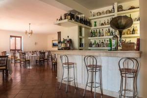 un restaurante con un bar con mesas y sillas en La Cascina Resort, en Casale la Cogna