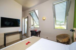 a bedroom with a bed and a flat screen tv at Gondwana City Green in Noumea