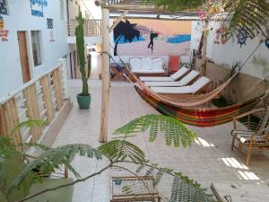 a hammock on a patio with a painting on the wall at Paracas Backpackers House in Paracas
