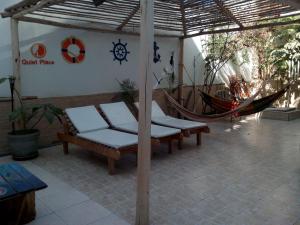 a patio area with chairs, tables, and umbrellas at Paracas Backpackers House in Paracas