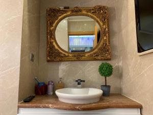 a bathroom with a sink and a mirror at PENTHOUSE GROUP 4 Apartments in Bucharest