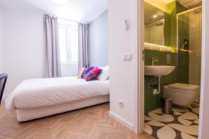 ein Schlafzimmer mit einem Bett, einem Waschbecken und einem WC in der Unterkunft Hostellicious in Faro