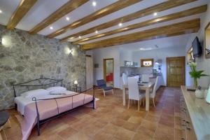 a bedroom with a bed and a stone wall at Apartments Stipe in Lukovo
