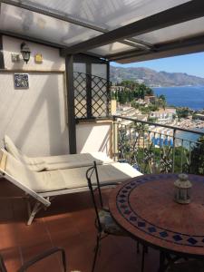 a table and chairs in a room with a view of the ocean at ToviMar Apartments in Taormina