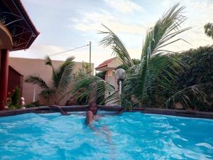 a young boy swimming in a swimming pool at Villa case authentique , in Saly Portudal