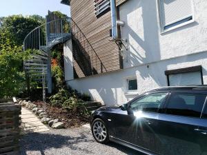 un coche negro estacionado frente a una casa en Haus am Schlossbach**** en Brannenburg