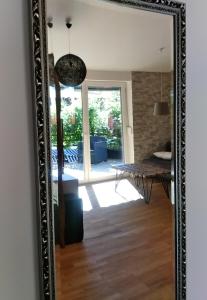 a mirror in a living room with a table and a dining room at Haus am Schlossbach**** in Brannenburg