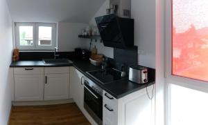 a small kitchen with a sink and a microwave at Haus am Schlossbach**** in Brannenburg