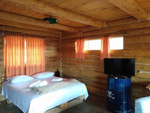 a bedroom with a bed and a flat screen tv at Morro do Vento in Picada Cafe