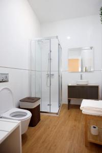 a bathroom with a shower and a toilet and a sink at Glass Boutique - Rooms & Suites in Marinha Grande