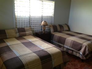 um quarto com duas camas e um candeeiro sobre uma mesa em My-Places Montego Bay Vacation Home em Montego Bay