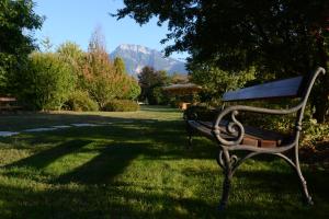 a park bench in the middle of a lush green field at Hotel Ambassador in Levico Terme